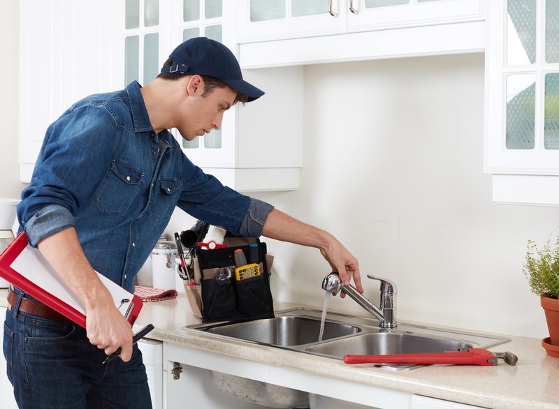 Professional plumber doing reparation in kitchen home