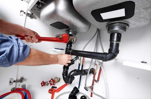 professional-plumber repairing kitchen sink